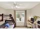 Well-lit bedroom featuring a bunk bed, window with curtains, ceiling fan, and a study area, creating a versatile space at 6050 Acorn Dr, Columbus, IN 47201