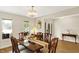 Elegant dining room with a chandelier, classic furniture, and plenty of natural light from the window at 6050 Acorn Dr, Columbus, IN 47201