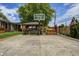 Large backyard features a basketball court, covered patio, seating area, and well-maintained lawn at 6143 Schoolwood Dr, Indianapolis, IN 46224