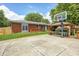 Spacious backyard featuring a basketball court, covered patio, and well-manicured lawn, perfect for outdoor activities at 6143 Schoolwood Dr, Indianapolis, IN 46224