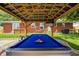 Backyard features a pool table under a covered patio with seating and well manicured landscaping at 6143 Schoolwood Dr, Indianapolis, IN 46224