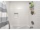 Bright bathroom with tub, shower, tiled wall, and convenient niche at 6143 Schoolwood Dr, Indianapolis, IN 46224