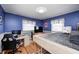 Bedroom with hardwood floors, blue walls, and a custom lofted bed at 6143 Schoolwood Dr, Indianapolis, IN 46224