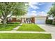 Charming brick ranch-style home featuring a lush green lawn and mature landscaping with inviting curb appeal at 6143 Schoolwood Dr, Indianapolis, IN 46224
