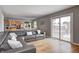 Living room with hardwood floors, gray couch, and access to the kitchen and outdoor space at 6143 Schoolwood Dr, Indianapolis, IN 46224