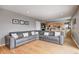 Living room with hardwood floors, gray couch, and access to the kitchen and dining room at 6143 Schoolwood Dr, Indianapolis, IN 46224