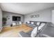 Cozy living room with hardwood floors, a gray couch, and a large entertainment center at 6143 Schoolwood Dr, Indianapolis, IN 46224