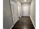 Hallway with dark laminate flooring and neutral-colored walls and white doors at 6729 Birmingham Ave, McCordsville, IN 46055