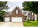 Charming brick home features a two-car garage and well-manicured lawn at 6771 Woodcliff Cir, Zionsville, IN 46077
