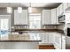 Bright kitchen featuring white cabinets, granite counters, and stainless appliances for easy meal prep at 6771 Woodcliff Cir, Zionsville, IN 46077