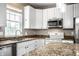 Close up of bright eat-in kitchen featuring granite counters, white cabinets, and stainless appliances at 6771 Woodcliff Cir, Zionsville, IN 46077