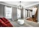 Comfortable living room, hardwood floors, with a modern light fixture and large windows at 6771 Woodcliff Cir, Zionsville, IN 46077