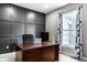 Well-lit home office featuring a dark accent wall, spacious desk, and a window with floral curtains at 6771 Woodcliff Cir, Zionsville, IN 46077