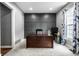 Bright home office with a stylish accent wall, large desk, and plenty of natural light from the window at 6771 Woodcliff Cir, Zionsville, IN 46077