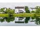 Beautiful pond view reflecting the rear exterior of a home with a deck and lush landscaping at 6771 Woodcliff Cir, Zionsville, IN 46077