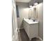 Modern bathroom featuring double sinks, updated fixtures, and wood-look flooring at 712 W Main St, Thorntown, IN 46071