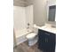 Bathroom featuring a subway tiled tub, a toilet, vanity, and wood-look flooring at 712 W Main St, Thorntown, IN 46071