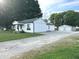 Exterior view of the house showing the gravel driveway, backyard and detached garage at 712 W Main St, Thorntown, IN 46071