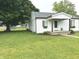 Quaint white home featuring a welcoming front porch, lush green lawn, and mature trees, with a clean, classic design at 712 W Main St, Thorntown, IN 46071