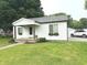 Charming single-story home with white siding, a well-manicured lawn, and flower boxes adorning the windows at 712 W Main St, Thorntown, IN 46071