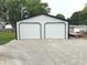 A spacious two car detached garage with white doors and black trim at 712 W Main St, Thorntown, IN 46071