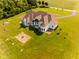 Picturesque aerial view featuring a charming home with lush lawn and a fire pit, surrounded by mature trees at 7493 W Lane Rd, McCordsville, IN 46055