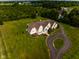 Aerial shot of an elegant home with manicured lawn, landscaping and a circular driveway at 7493 W Lane Rd, McCordsville, IN 46055