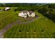 Picturesque aerial view featuring a charming home, surrounded by a sprawling green lawn and mature trees at 7493 W Lane Rd, McCordsville, IN 46055