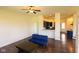 Spacious living room with hardwood floors and a view into the kitchen, complemented by a modern blue sofa at 7493 W Lane Rd, McCordsville, IN 46055