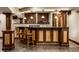 Basement bar with wood columns, seating for two, and modern lighting at 7743 Camelback Dr, Indianapolis, IN 46250