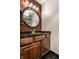 Elegant powder room with granite countertops, a round mirror, and dark wood cabinetry at 7743 Camelback Dr, Indianapolis, IN 46250