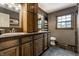 A full bathroom featuring a double sink vanity with dark wood cabinets and a large window for natural light at 7743 Camelback Dr, Indianapolis, IN 46250