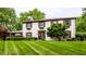 Charming two-story home with a well-manicured lawn, dark shutters, flower boxes, and a welcoming front door at 7743 Camelback Dr, Indianapolis, IN 46250