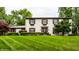 Charming two-story home with a well-manicured lawn, dark shutters, flower boxes, and a welcoming front door at 7743 Camelback Dr, Indianapolis, IN 46250