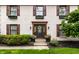 Welcoming front entrance featuring a decorative wreath, stylish sconces, and flower-filled planters at 7743 Camelback Dr, Indianapolis, IN 46250