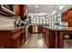 Kitchen with stainless steel appliances, dark wood cabinets, granite counters, and an island at 7743 Camelback Dr, Indianapolis, IN 46250