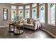 Sun-filled living area with a comfortable sofa, decorative pillows, and multiple large windows at 7743 Camelback Dr, Indianapolis, IN 46250
