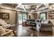Inviting living room features coffered ceilings, built-in bookshelves, and access to an outdoor pool area at 7743 Camelback Dr, Indianapolis, IN 46250
