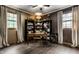 Home office with hardwood floors, built-in bookshelves, and natural light from two large windows at 7743 Camelback Dr, Indianapolis, IN 46250