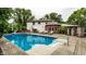 Large in-ground swimming pool with brick patio, lush landscaping, and inviting seating, great for entertaining and relaxation at 7743 Camelback Dr, Indianapolis, IN 46250