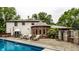 An inviting backyard pool with sun loungers, and an outdoor dining set for relaxation at 7743 Camelback Dr, Indianapolis, IN 46250
