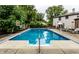 Refreshing in-ground pool with a diving board, brick patio, and lush landscaping, perfect for summer relaxation and fun at 7743 Camelback Dr, Indianapolis, IN 46250