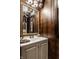 Stylish powder room features a decorative mirror, vanity, and patterned wallpaper at 7743 Camelback Dr, Indianapolis, IN 46250