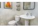 Elegant bathroom features a pedestal sink, modern toilet, and decorative wall art and fixtures at 8568 Goldfinch Rd, Brownsburg, IN 46112