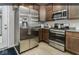 Compact kitchen showcases stainless steel appliances, granite counters, and sleek wood cabinetry for a modern look at 8568 Goldfinch Rd, Brownsburg, IN 46112