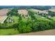 Expansive aerial view of a home and property surrounded by green trees and agricultural land at 8818 Mathews Rd, Indianapolis, IN 46259