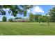 Large backyard with brick home, mature trees, and manicured lawn at 8818 Mathews Rd, Indianapolis, IN 46259