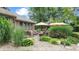 Stone patio with patio seating, lush landscaping and two sun umbrellas at 8818 Mathews Rd, Indianapolis, IN 46259