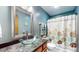 Bathroom featuring blue walls, glass bowl sink, and decorative shower curtain at 8818 Mathews Rd, Indianapolis, IN 46259