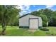 Spacious outbuilding with a large roll-up door, surrounded by a green lawn and mature trees at 8818 Mathews Rd, Indianapolis, IN 46259
